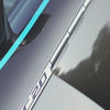 Close-up of TeckWrap black carbon fiber wrap applied on car hood with striking reflection and detail lines.