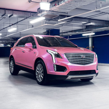 Sleek Cadillac SUV wrapped in TeckWrap Wild Heather (DS05-HD) gloss vinyl, featuring a vivid and luxurious pink finish, parked in a modern underground setting.